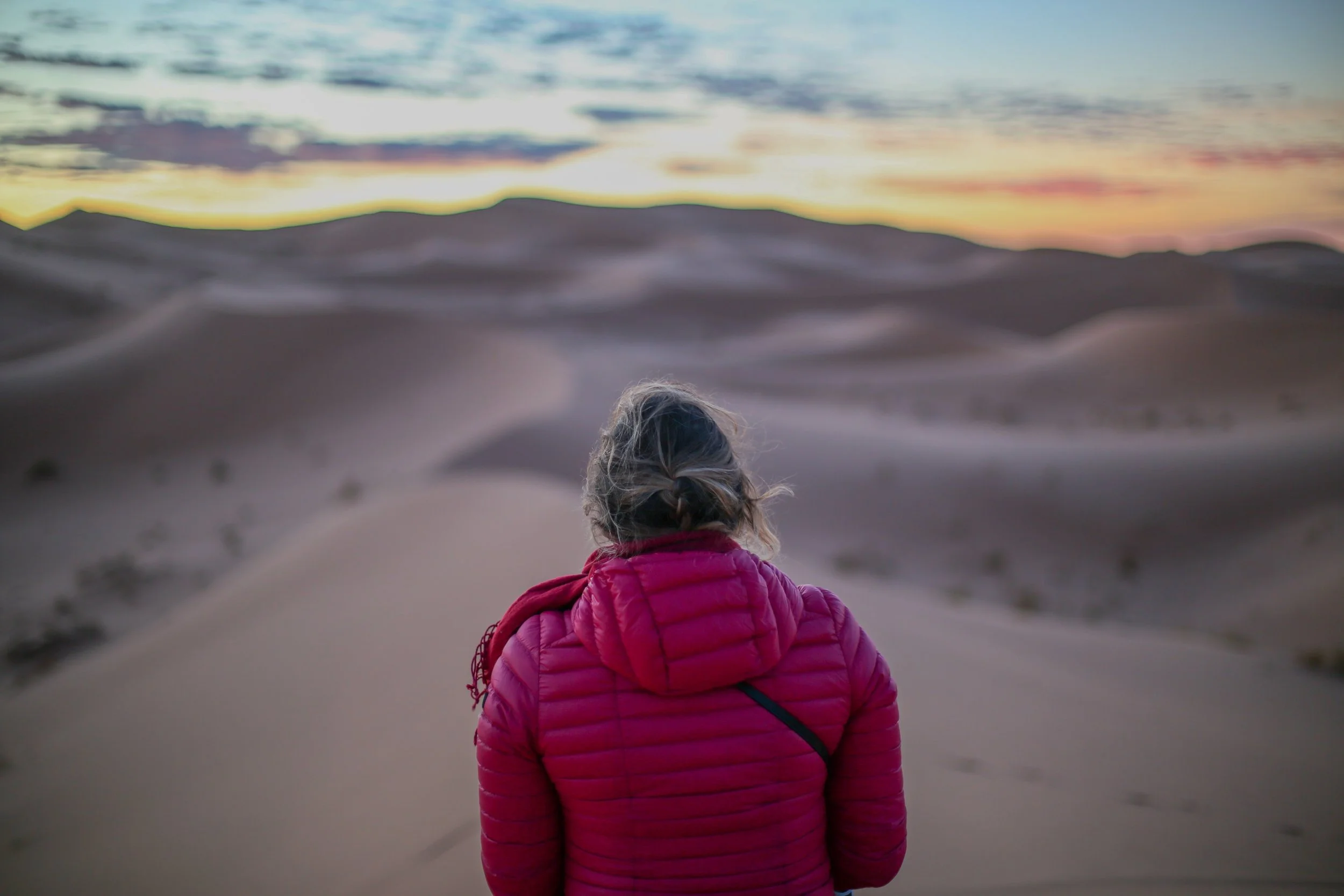 Solo female traveler exploring desert at sunrise, embracing the freedom and empowerment of solo travel with Greether’s trusted local female guides for safe and confident travel experiences.